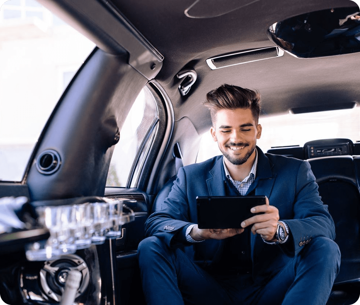 Man in suit using tablet in limousine