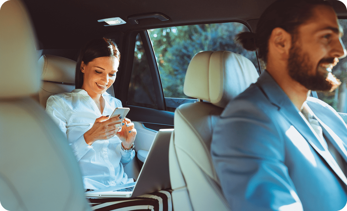 Passenger working on laptop in vehicle